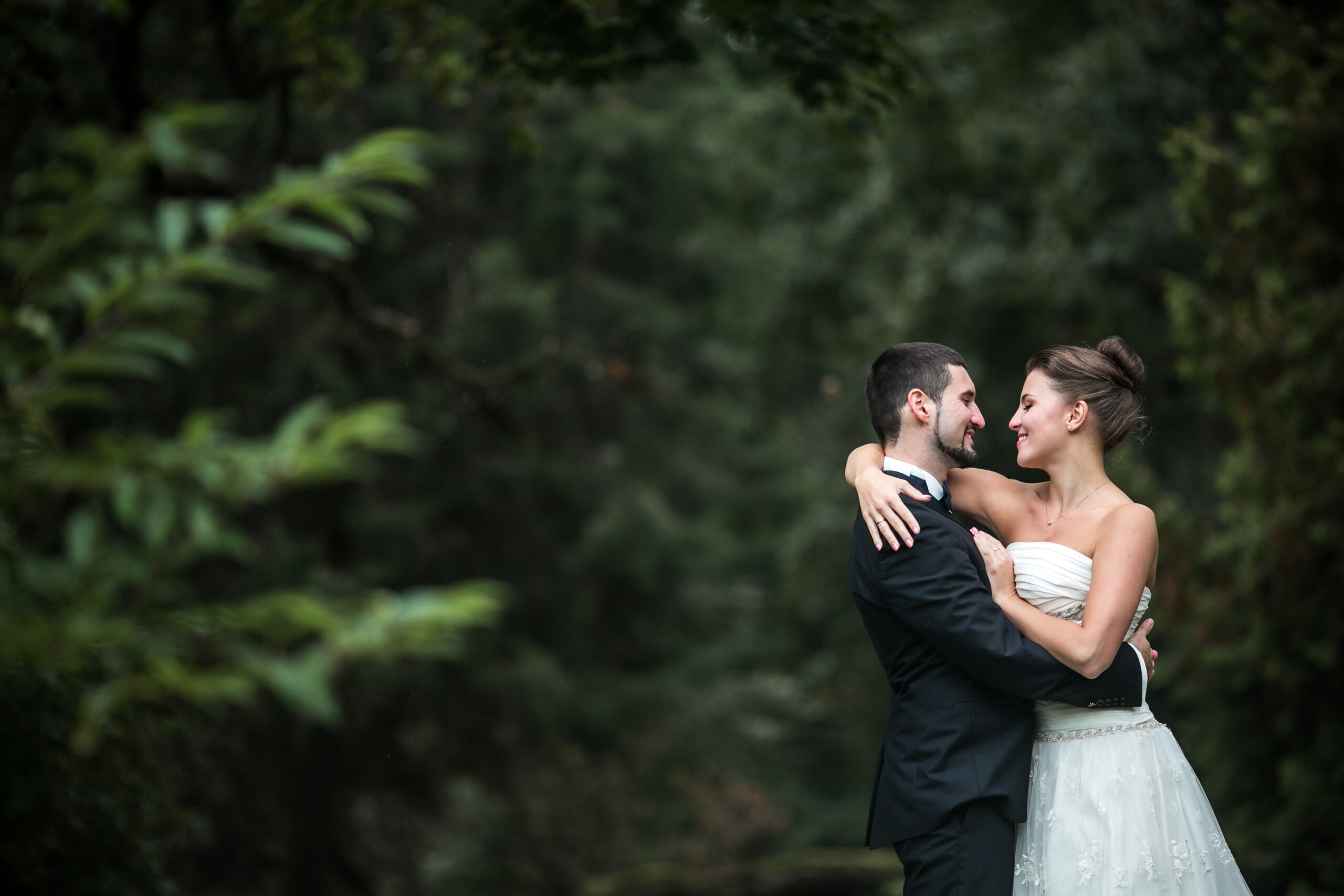 Beautiful wedding couple in each other's arms in the park